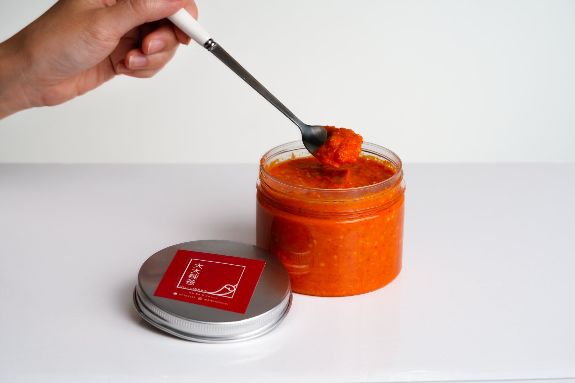 Signature Chilli in a glass jar with a spoon